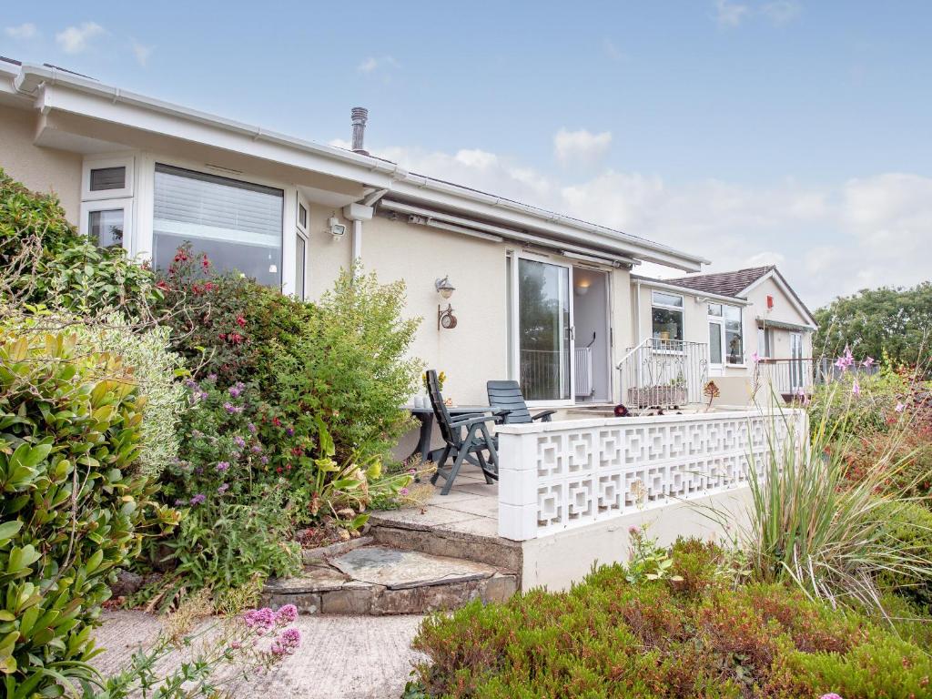 a house with a porch with a bench on the porch at Leighwood Cottage in Paignton