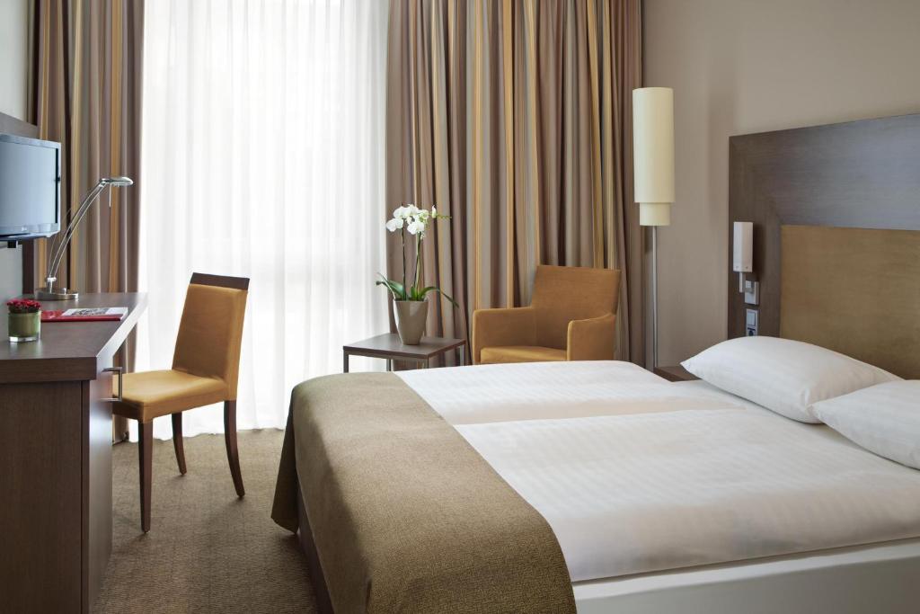 
a hotel room with two beds and a television at InterCityHotel Darmstadt in Darmstadt
