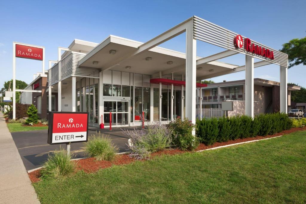 a building with a red sign in front of it at Ramada by Wyndham Rockville Centre in Rockville Centre