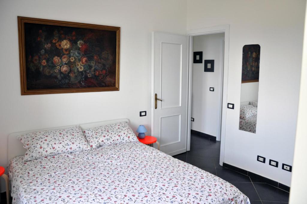 1 dormitorio con 1 cama y una pintura en la pared en La Rimessa, en Bonassola