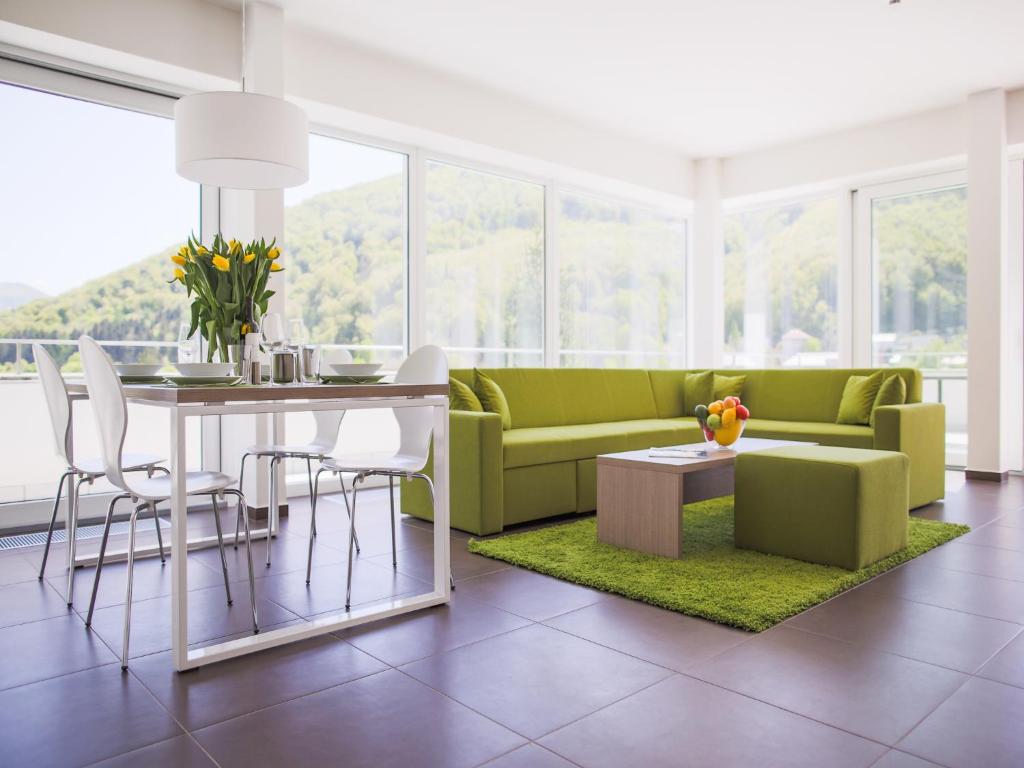 a living room with a green couch and a table at Villa Irene in Martinske Hole