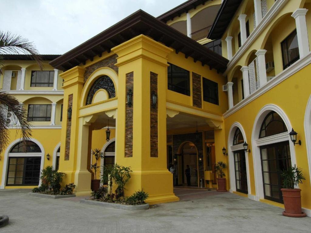 a yellow building with a front entrance at Planta Centro Bacolod Hotel & Residences in Taculing Hacienda