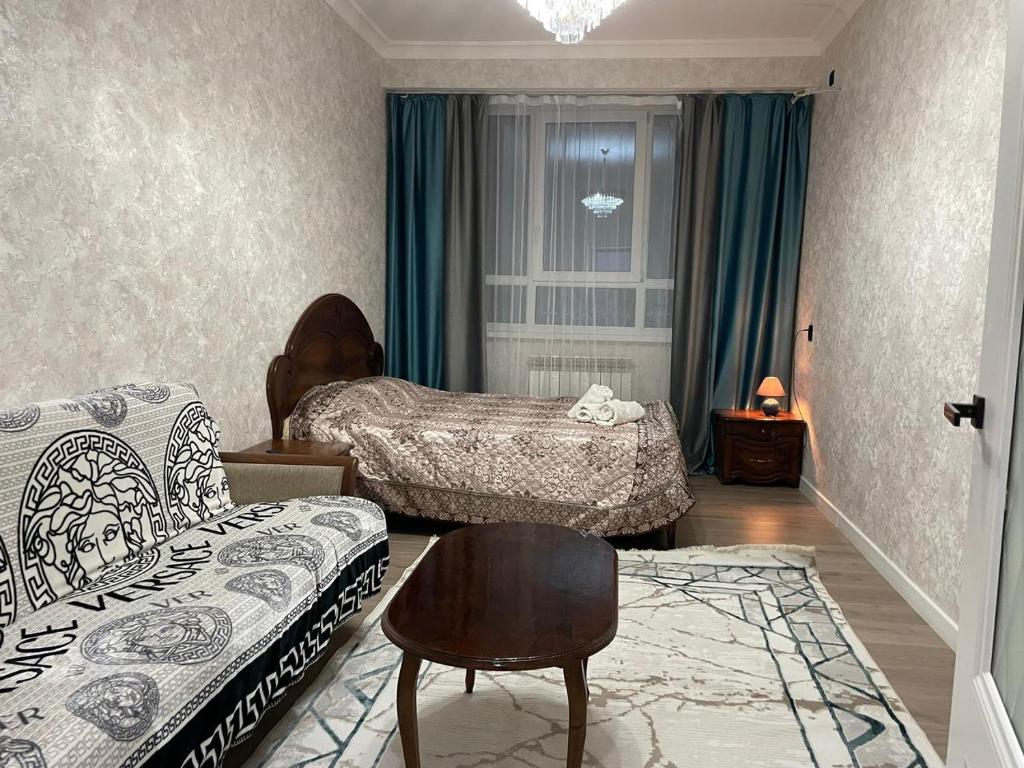 a living room with two beds and a chair at ЖК Prime park in Shymkent