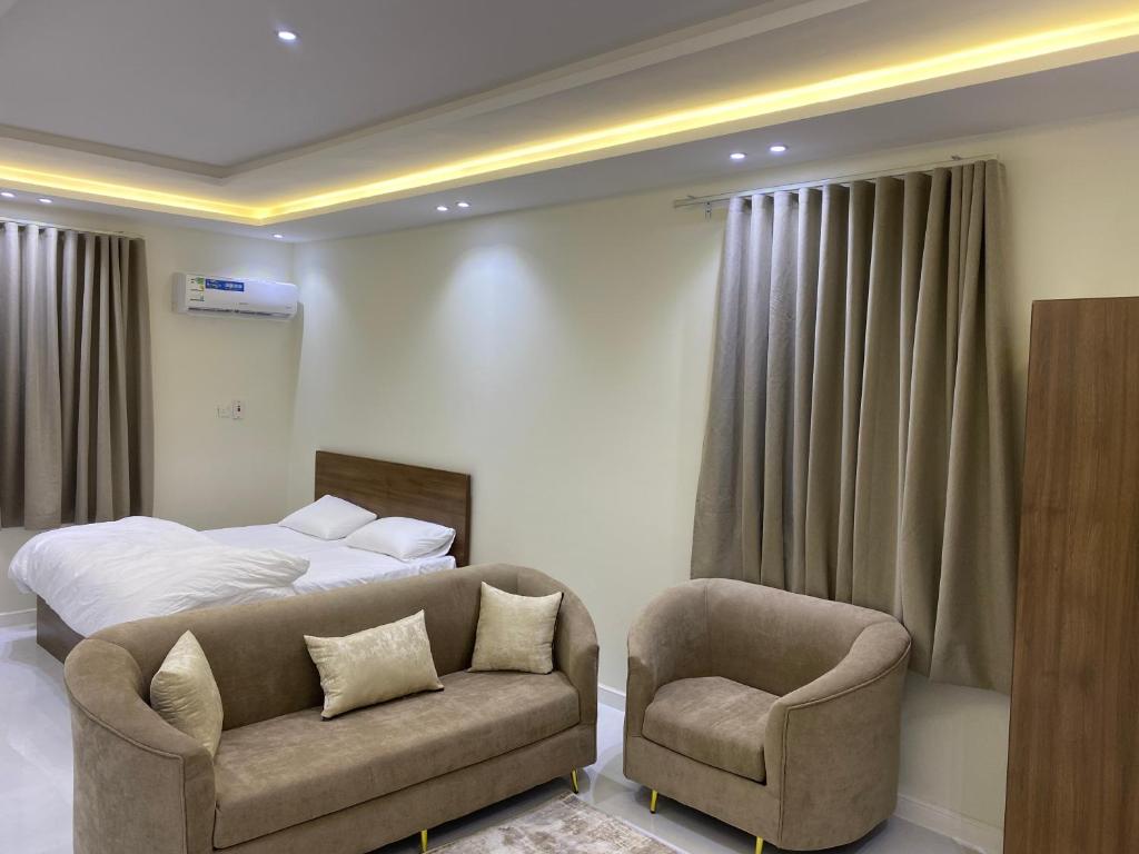 a bedroom with a bed and a couch and a chair at شقق الضباب 2 in Al Baha