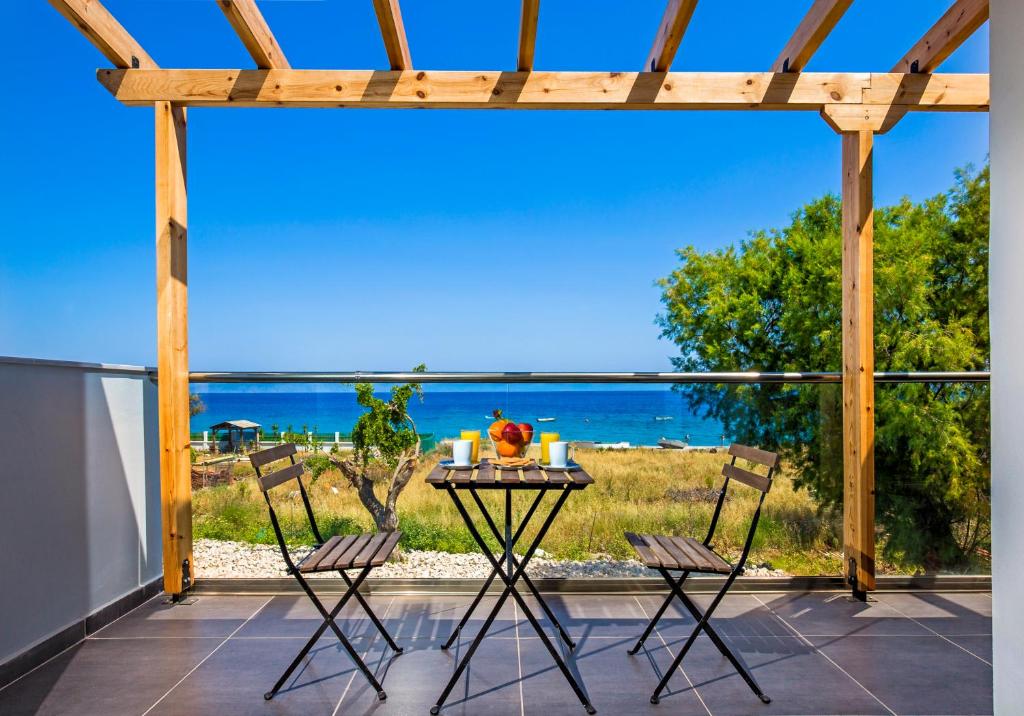 a table on a patio with a view of the ocean at Rhodes Sea Villas in Ixia