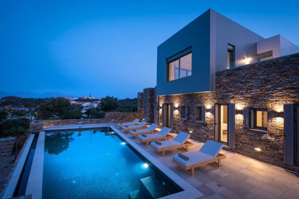 a villa with a swimming pool at night at Villa Hermione in Agios Nikolaos