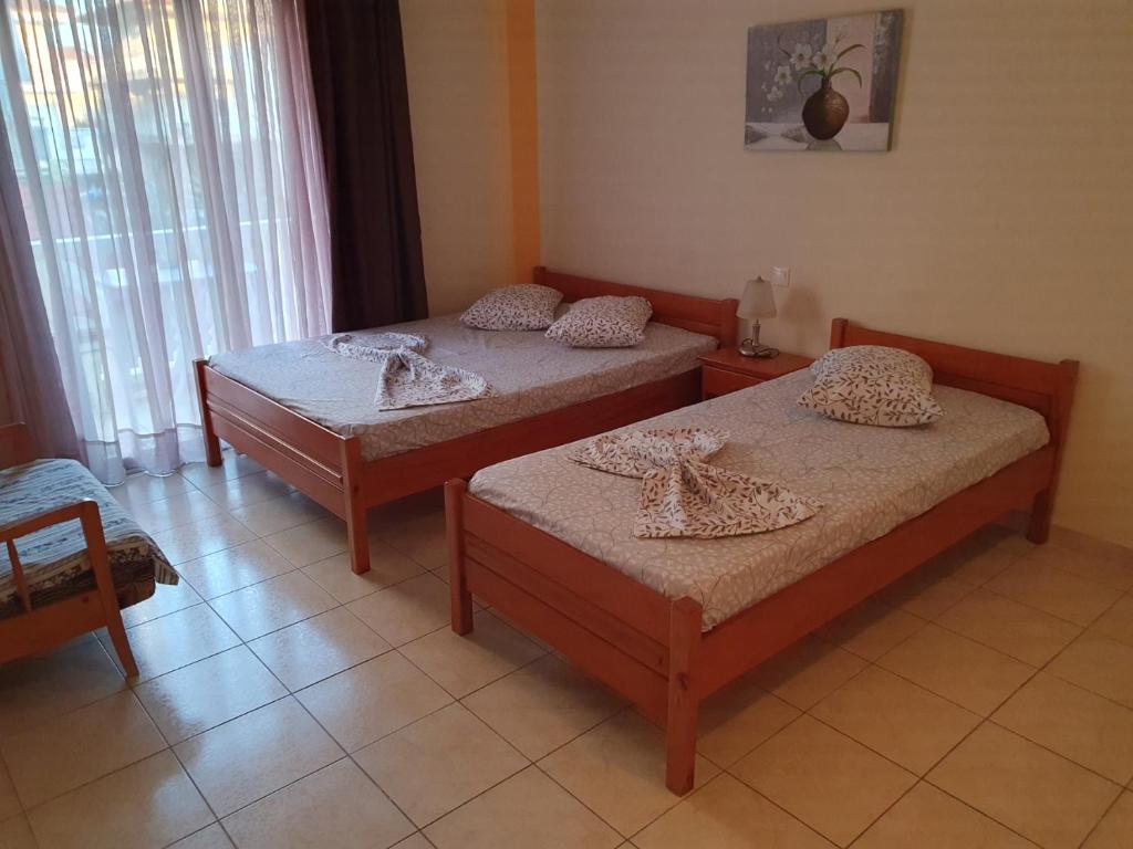 a bedroom with two beds and a window at Villa Anastasia Olympic Beach in Olympiaki Akti