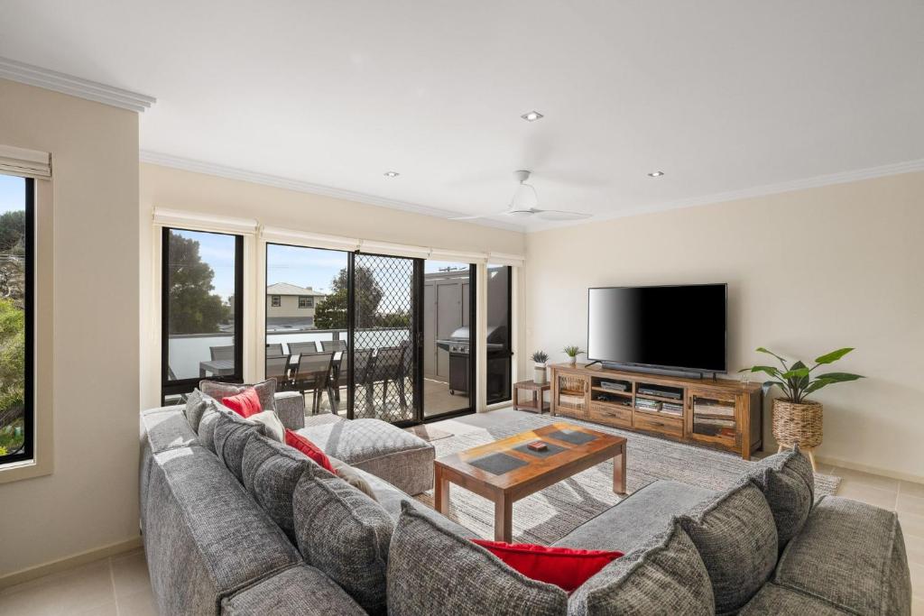 a living room with a couch and a tv at Brooklya by the Beach in Cowes