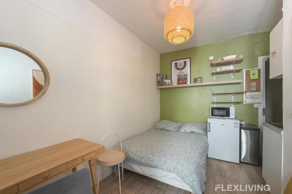 une petite pièce avec un lit et une table dans l'établissement Flexliving - Studio - Hopital, à Paris