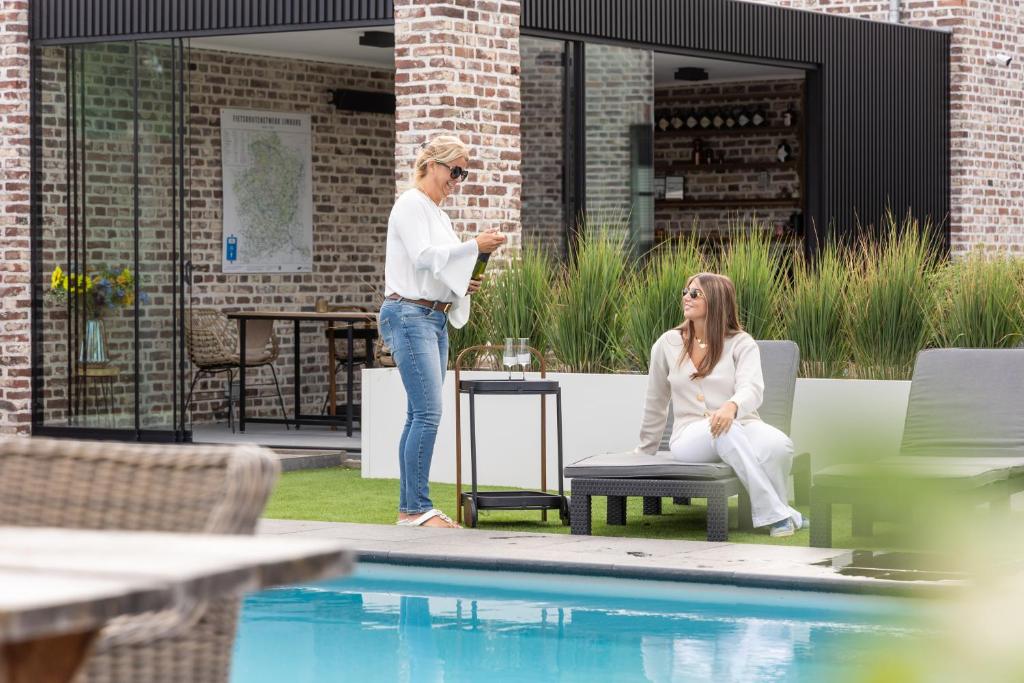 two women are standing next to a pool at Luna Logies in Lanaken