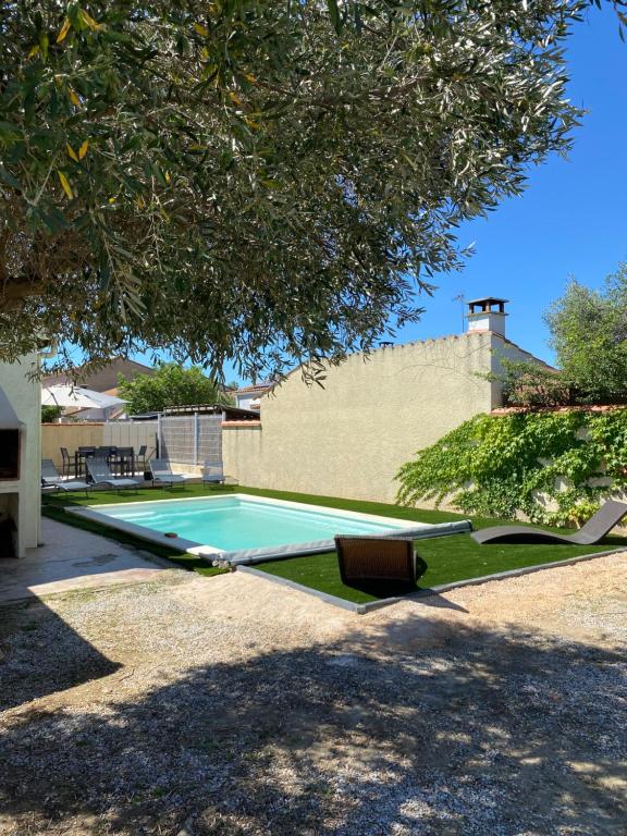 - un hamac dans une cour à côté de la piscine dans l'établissement Maison avec piscine et jardin, à Salses-le-Chateau