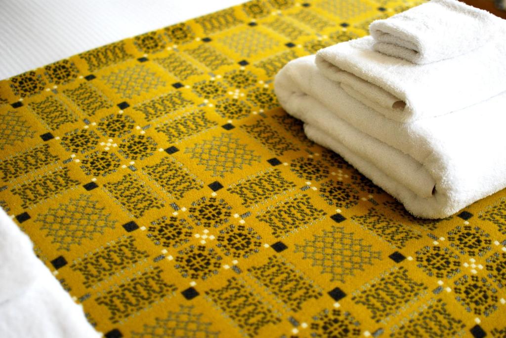 聖大衛的住宿－Ty Boia Bed & Breakfast，一张黄色和黑色的桌子,上面有毛巾