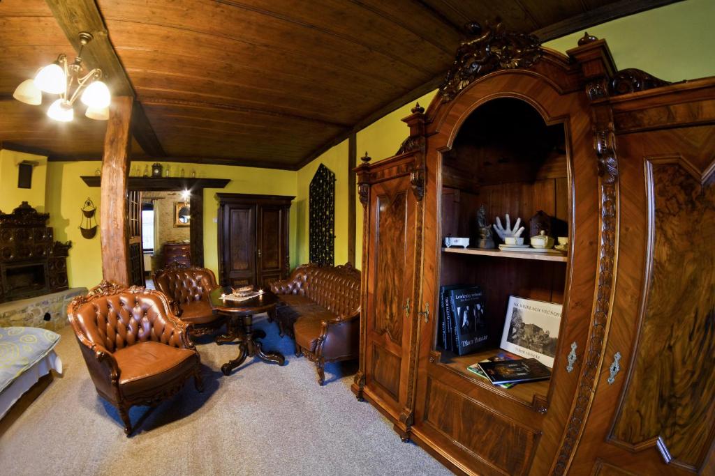 una sala de estar con un gran armario de madera y sillas en Antik Apartmán Levoča, en Levoča