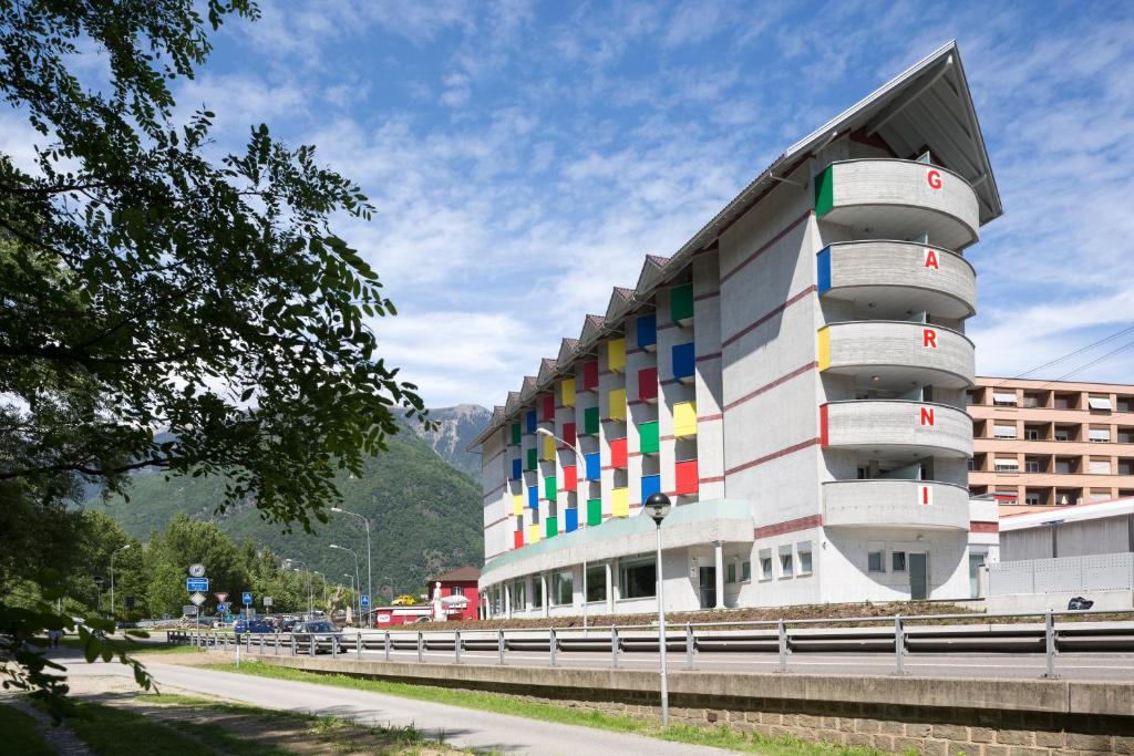 een gebouw met kleurrijke balkons aan de zijkant bij Hotel Liberty Self Check-In in Bellinzona