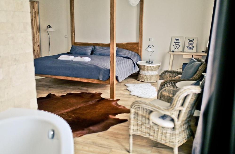 1 dormitorio con cama, sofá y sillas en Anděl Penzion & Cafe en Rožnov pod Radhoštěm