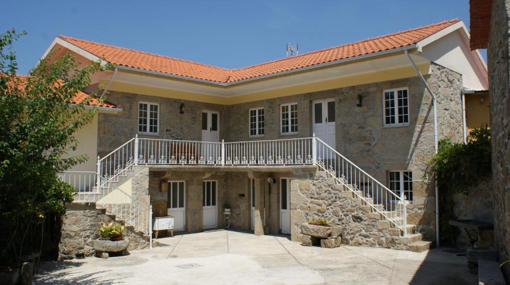 a large stone building with a staircase in front of it at Casa Serra do Lagar in Ribeiradio