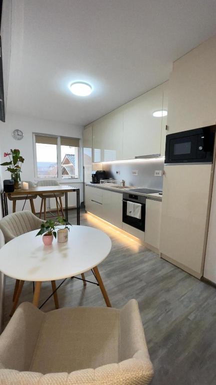 a kitchen with a table and a kitchen with a refrigerator at DreamApartment in Deva