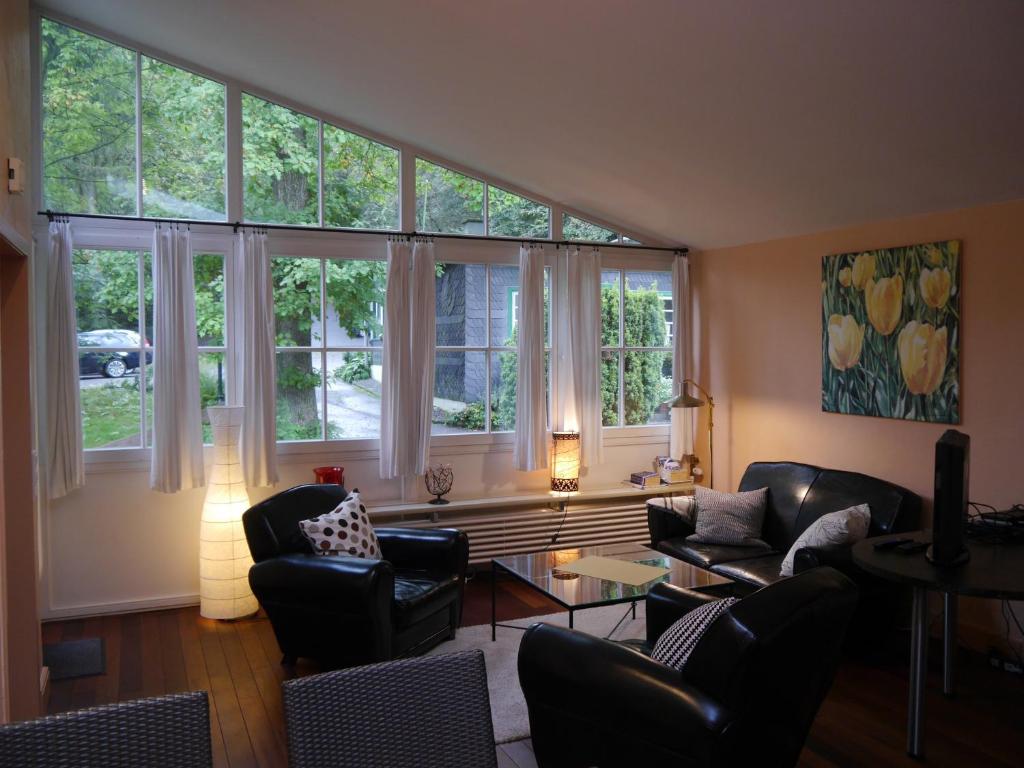 a living room with a lot of windows at Haus Honigstal Landhaus Café in Wuppertal