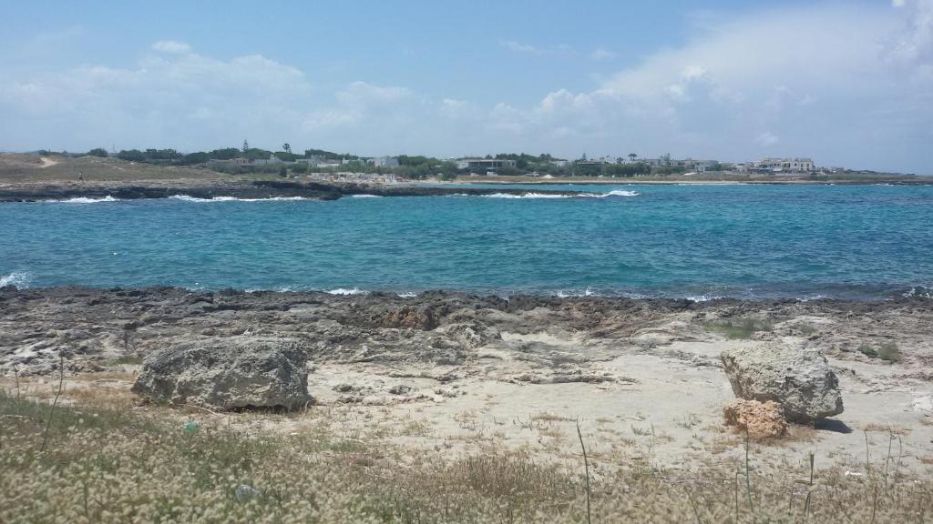 a beach with rocks and the ocean in the background at Hotel Corallo in Torre Santa Sabina