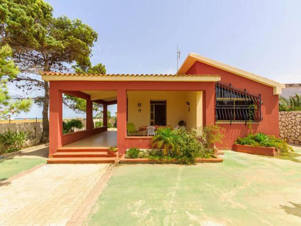 una pequeña casa con un rojo y amarillo en Villa Posidonie, en Marausa