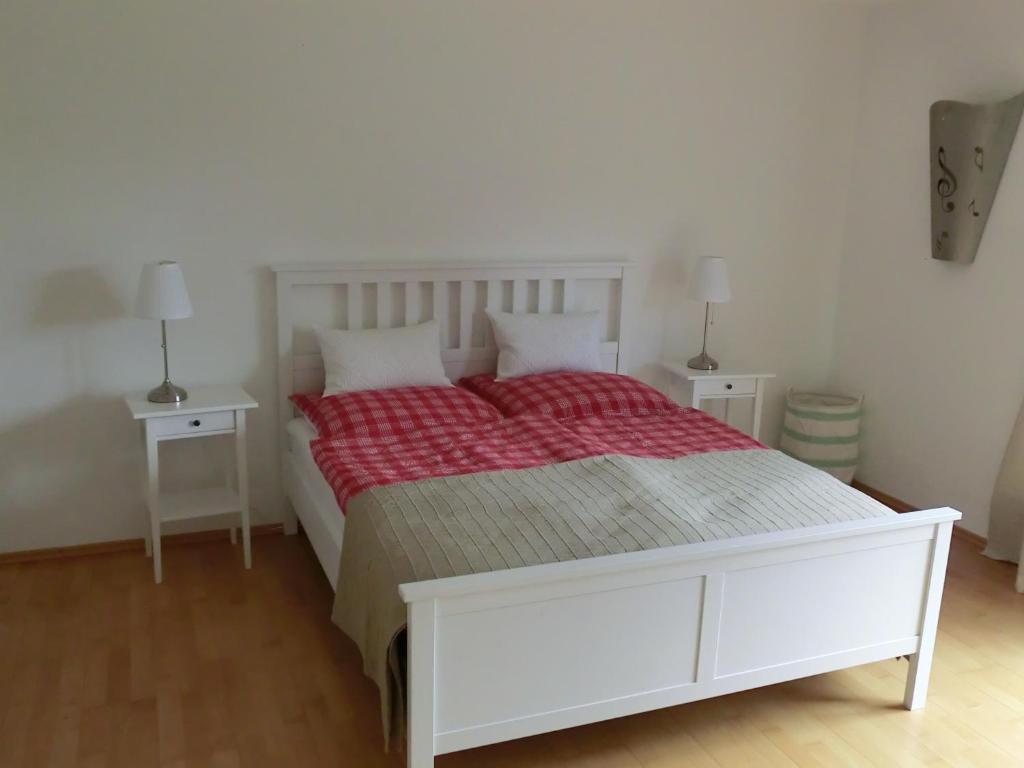 a bedroom with a white bed and two night stands at Ferienwohnung Mozart Bayreuth in Bayreuth