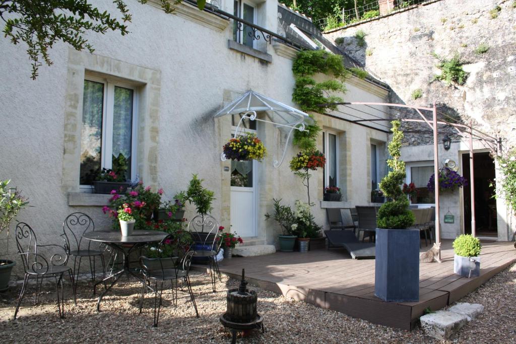 un patio frente a una casa con mesa y sillas en Clos Mariotte en Vouvray