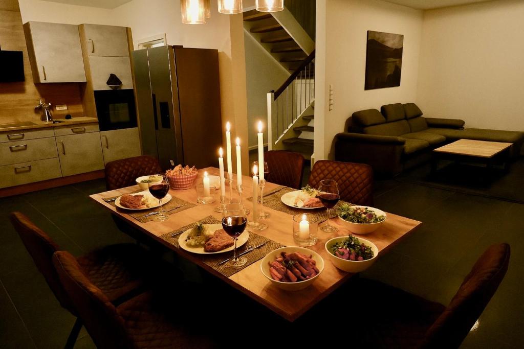Una mesa con platos de comida y velas sobre ella. en Modernes Ferienhaus bei Lüneburg Terrasse, Grill & Garten für 6 Gäste, en Artlenburg