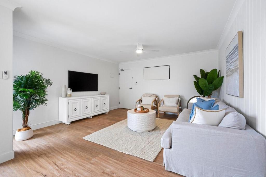 a living room with a couch and a tv at Sundaze at Kingy Creek in Kingscliff