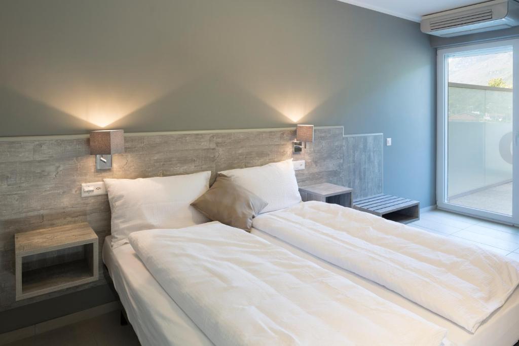 a large bed in a room with a large window at Hotel Liberty Self Check-In in Bellinzona