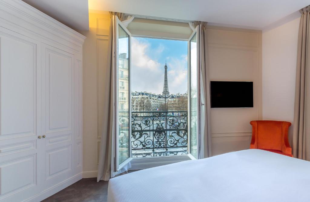 a bedroom with a view of the eiffel tower at Hôtel La Comtesse in Paris