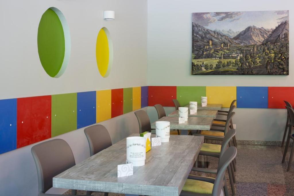 a row of tables in a restaurant with chairs at Hotel Liberty Self Check-In in Bellinzona