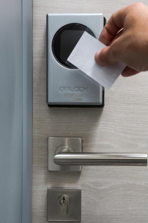 a person inserting a piece of paper into a door at Hotel Liberty Self Check-In in Bellinzona