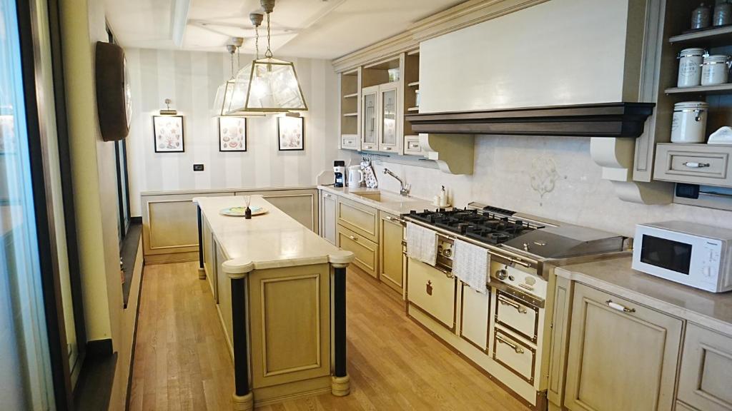 a kitchen with white cabinets and a stove top oven at Domus Luxury villa Alassio in Alassio