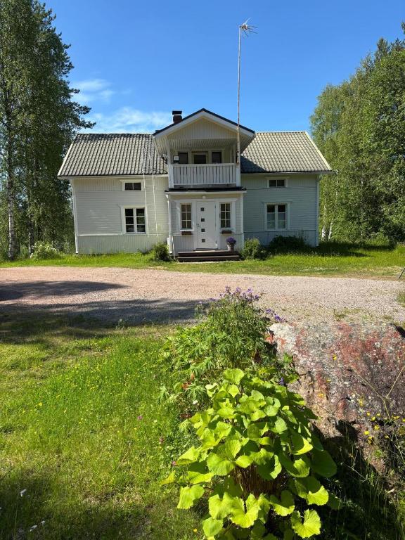 a white house with a porch on a road at Villa Lempeänranta in Pello