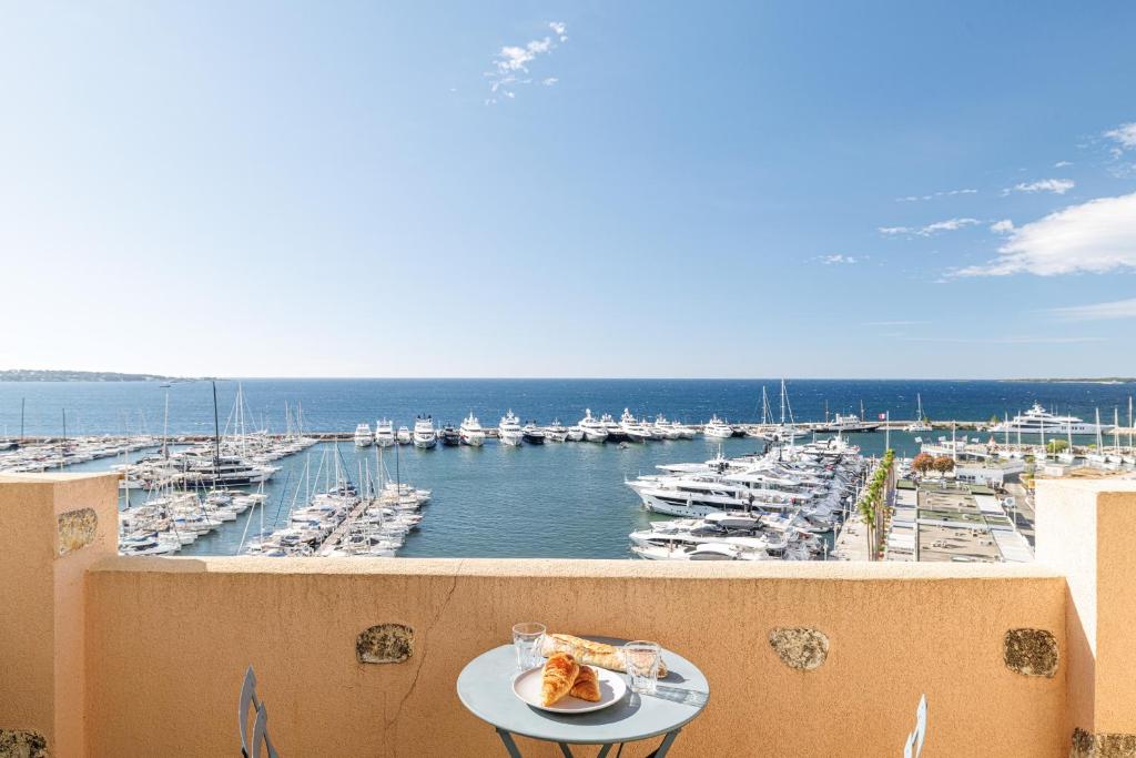 une vue d'une marina depuis un balcon dans l'établissement GRAND PALAIS - Beautiful top floor studio - Sea front with AC, à Vallauris