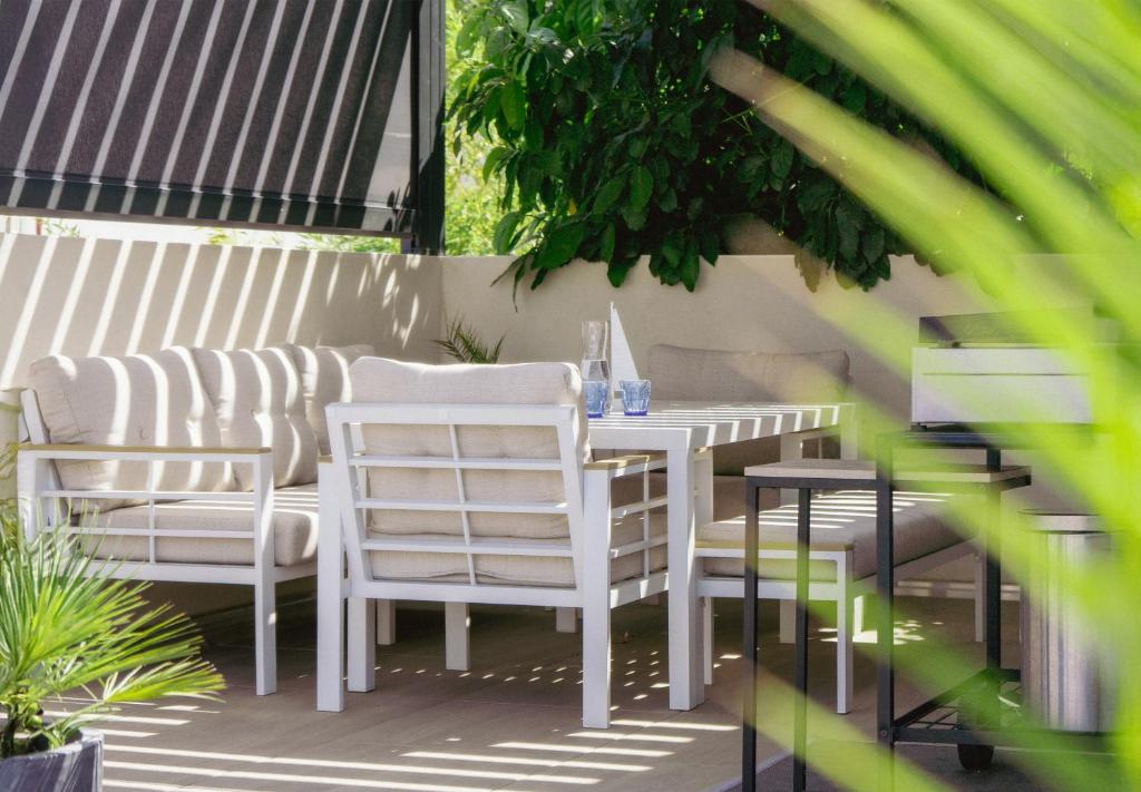 a white table and chairs on a patio at 36 2 l air marin Penthouse Netflix Clim Free park Navette Grands Buffets Accès direct autoroute et plages in Narbonne