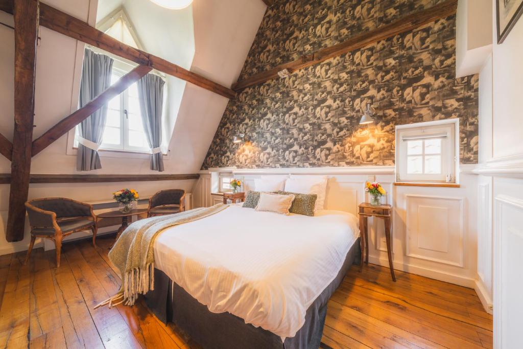 a bedroom with a bed and a stone wall at B&B Number 11 Exclusive Guesthouse in Bruges