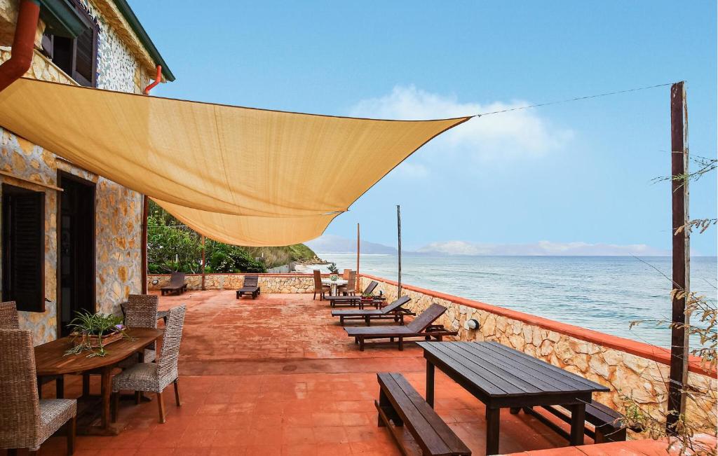 a patio with tables and chairs and the ocean at Amazing Apartment In Trappeto With Wifi in Trappeto
