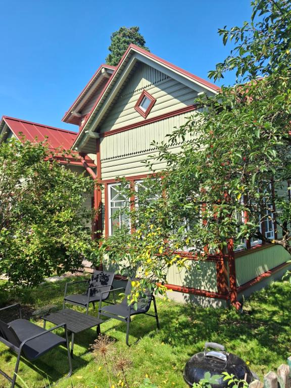 a house with two benches and a tree at Villa Manna - Charming Flat in a Historic House in Tallinn