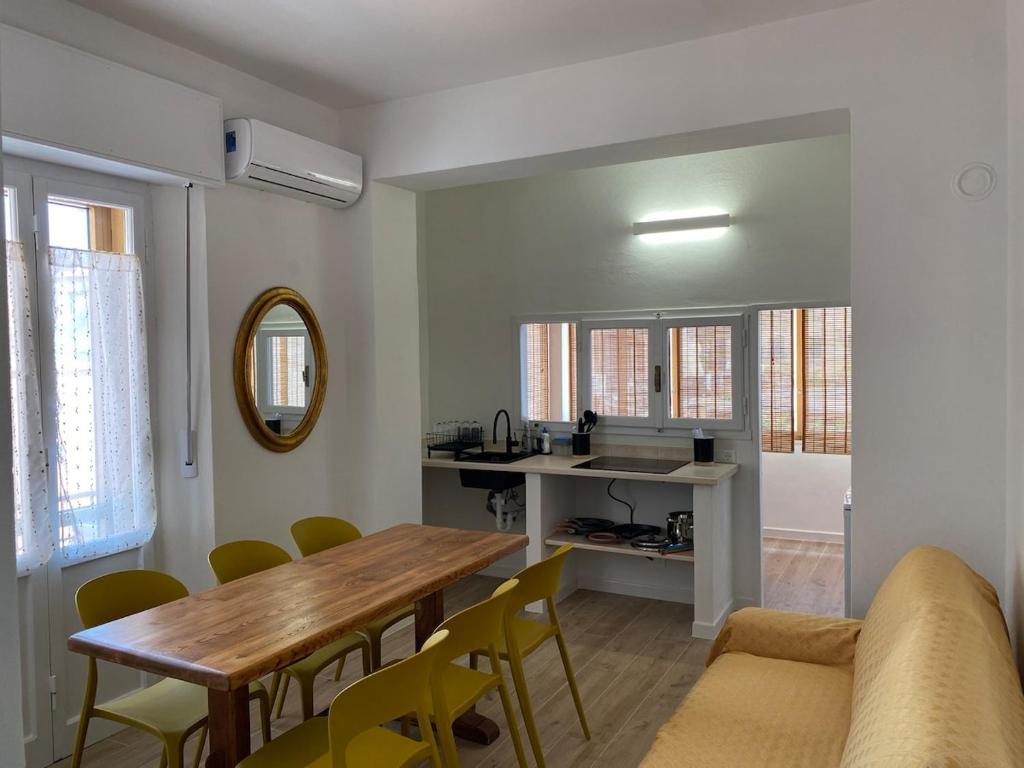 une cuisine et une salle à manger avec une table et des chaises en bois dans l'établissement La Casa di Didi, à Porto Azzurro