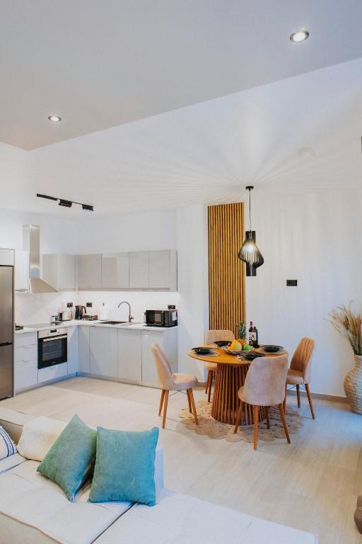 a kitchen and living room with a table and chairs at Lambi beach City Suite in Kos
