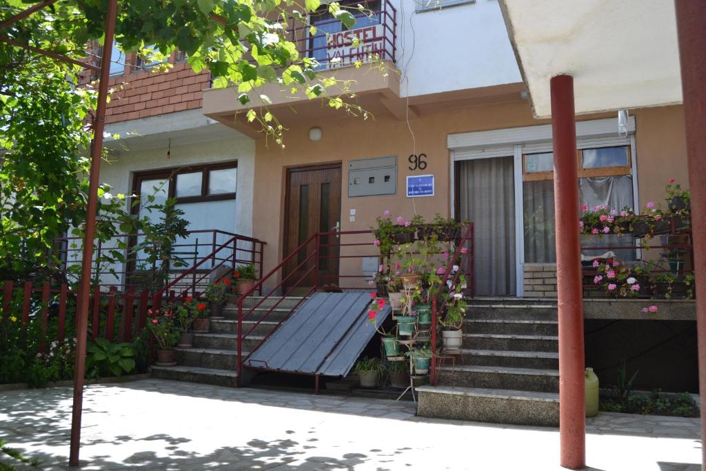 une maison avec un banc devant elle dans l'établissement Hostel Valentin, à Ohrid