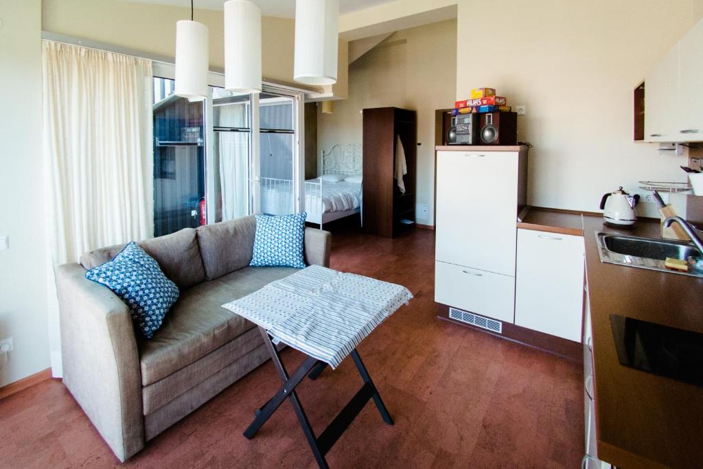 a living room with a couch and a table in a kitchen at Lapės namai in Pervalka