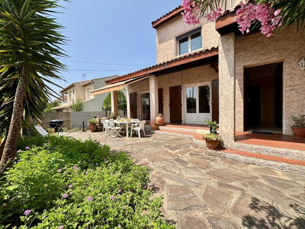 a patio of a house with a table and chairs at L'Escapade du Midi in La Celle-sous-Gouzon