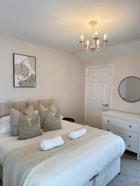 ein weißes Schlafzimmer mit einem großen Bett mit zwei Kissen in der Unterkunft Rickmansworth Lodge in Rickmansworth