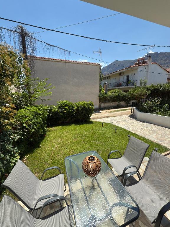 a glass table with chairs and a vase on it at Prime Diakopto in Diakopto