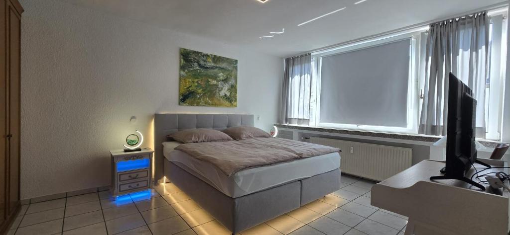 a bedroom with a bed and a flat screen tv at Vacation and business city apartment in Mönchengladbach