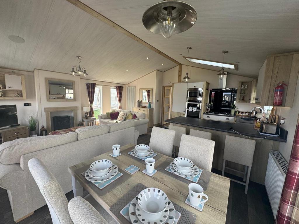 una sala de estar con un sofá y una mesa en Harrogate Lodge, Bude, en Poughill