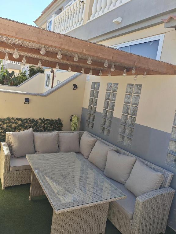a patio with a couch and a glass table at Avenue Study in El Médano