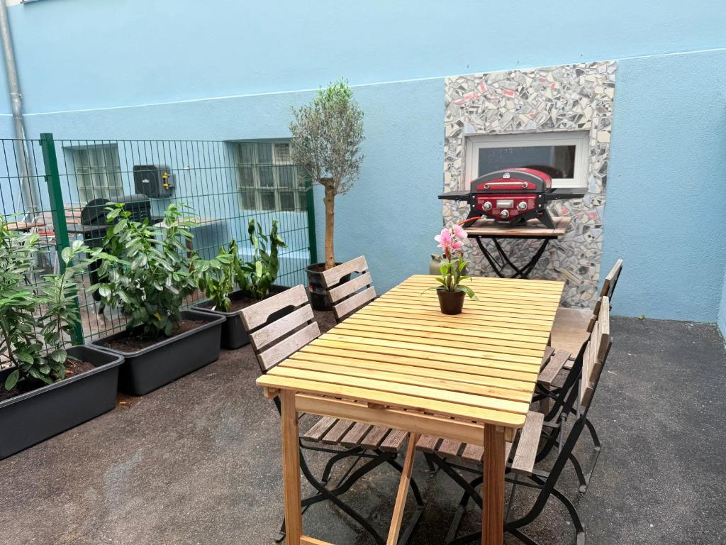 a wooden table and chairs on a patio with plants at Chill and Grill for 2 in Vienna